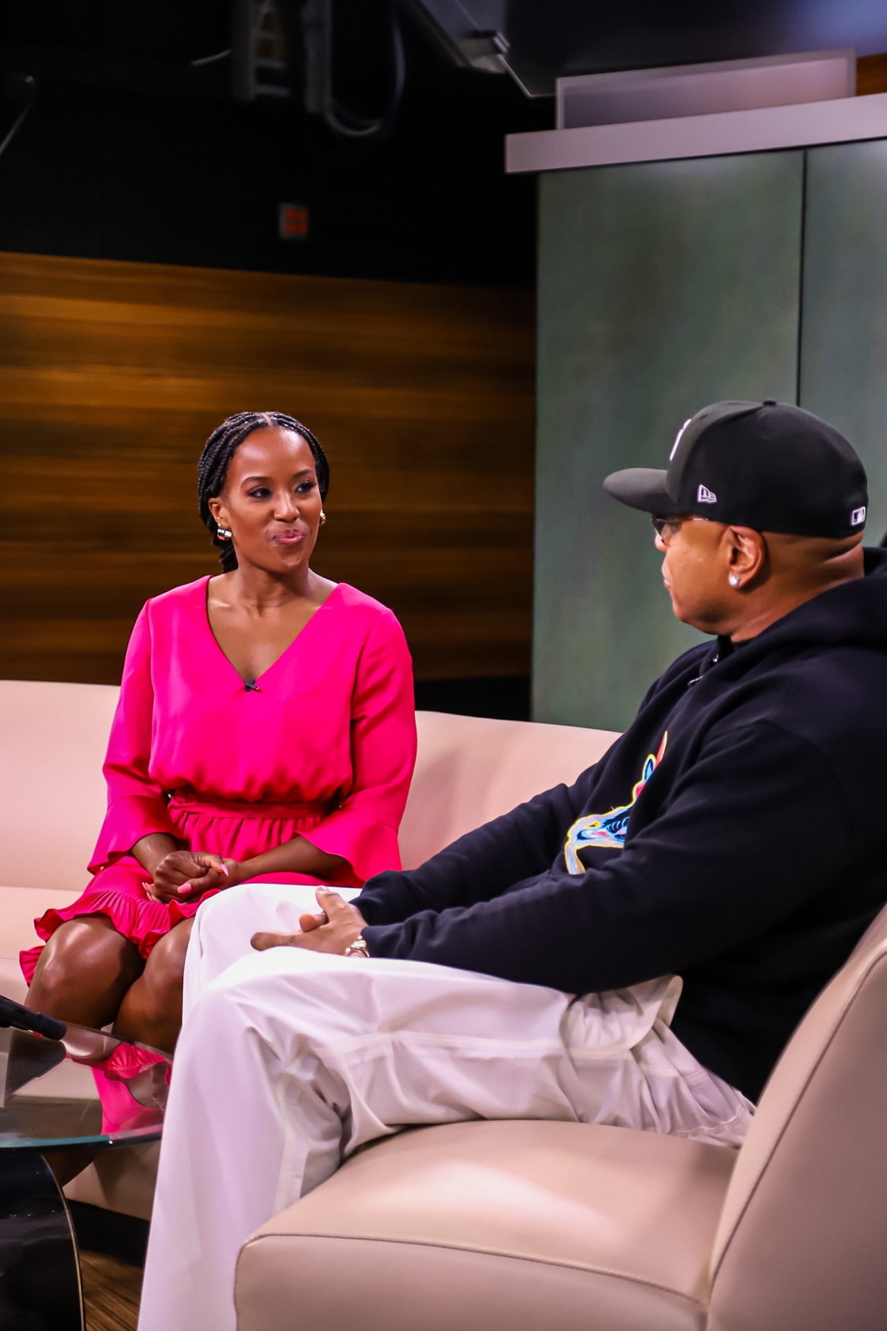 Megan Rivers interviewing LL COOL J on set in a pink dress